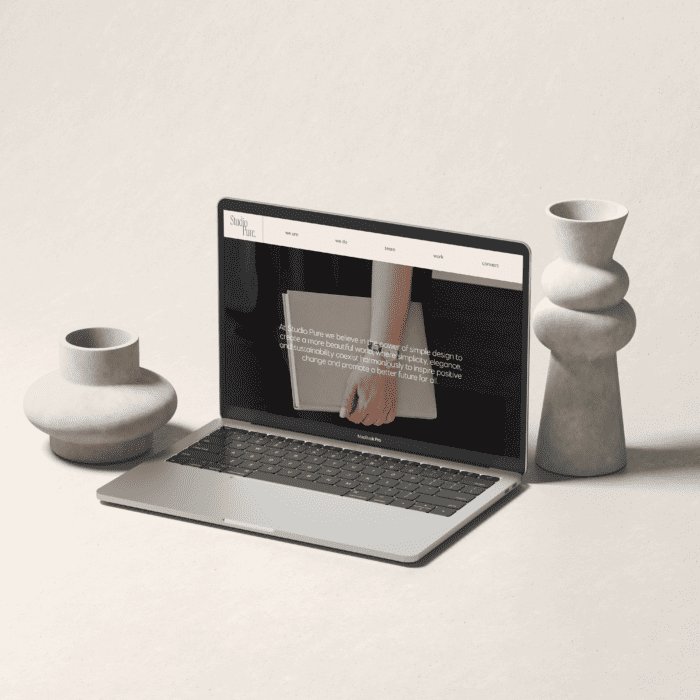 A laptop is sitting on a table next to vases and a vase, belonging to a WordPress Designer.