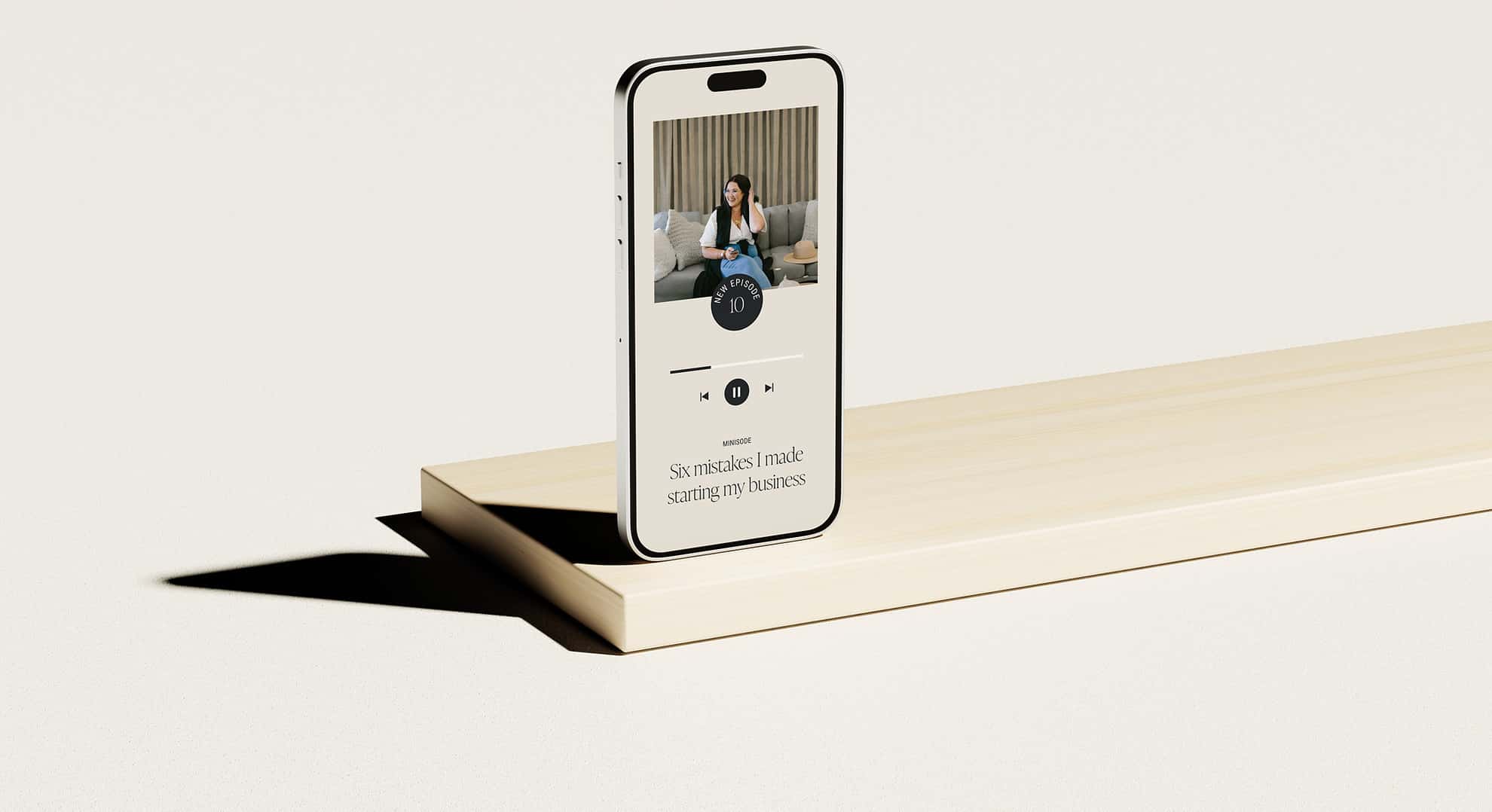 An iPhone is sitting on top of a wooden shelf.