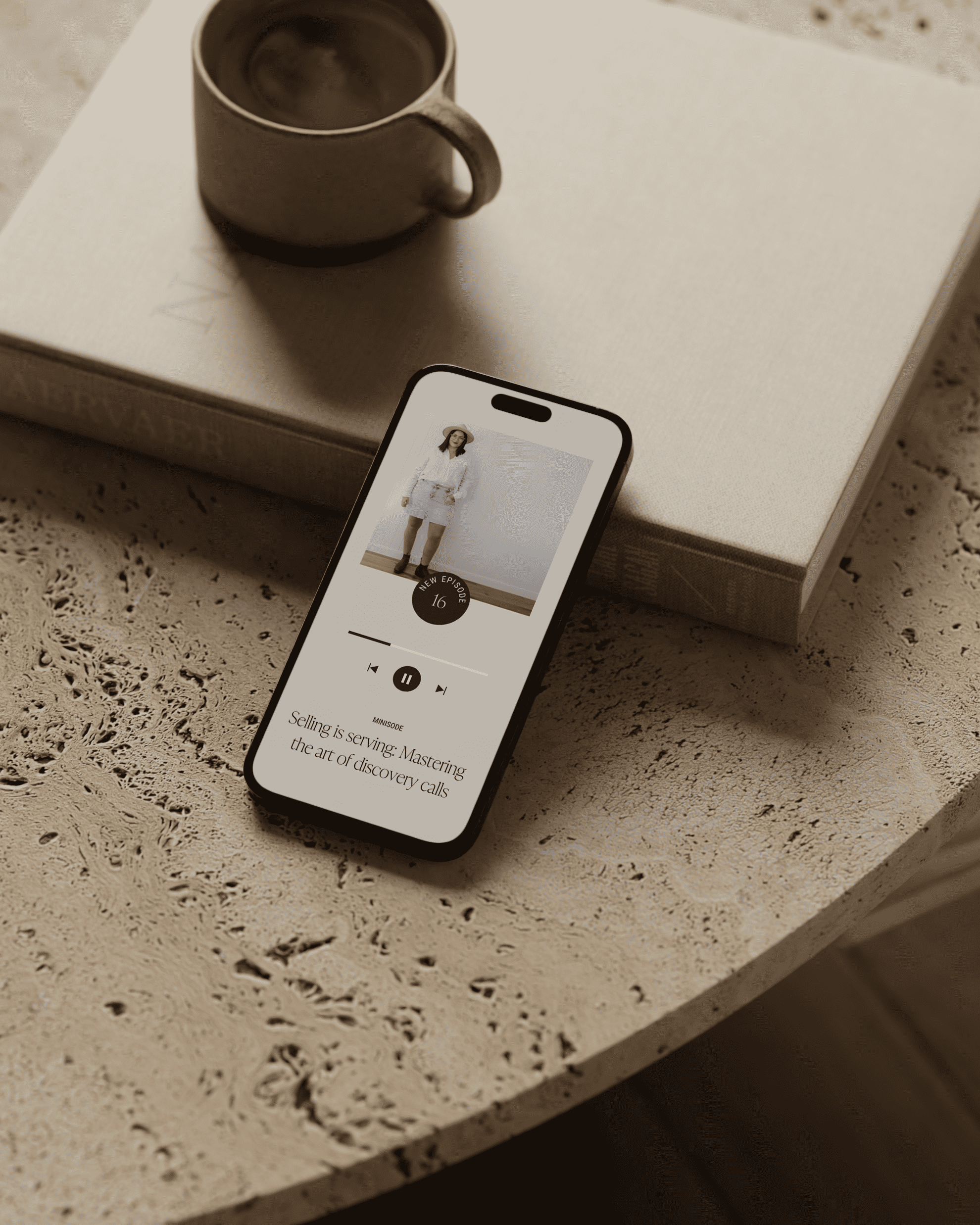 A phone with a cup of coffee on a table.